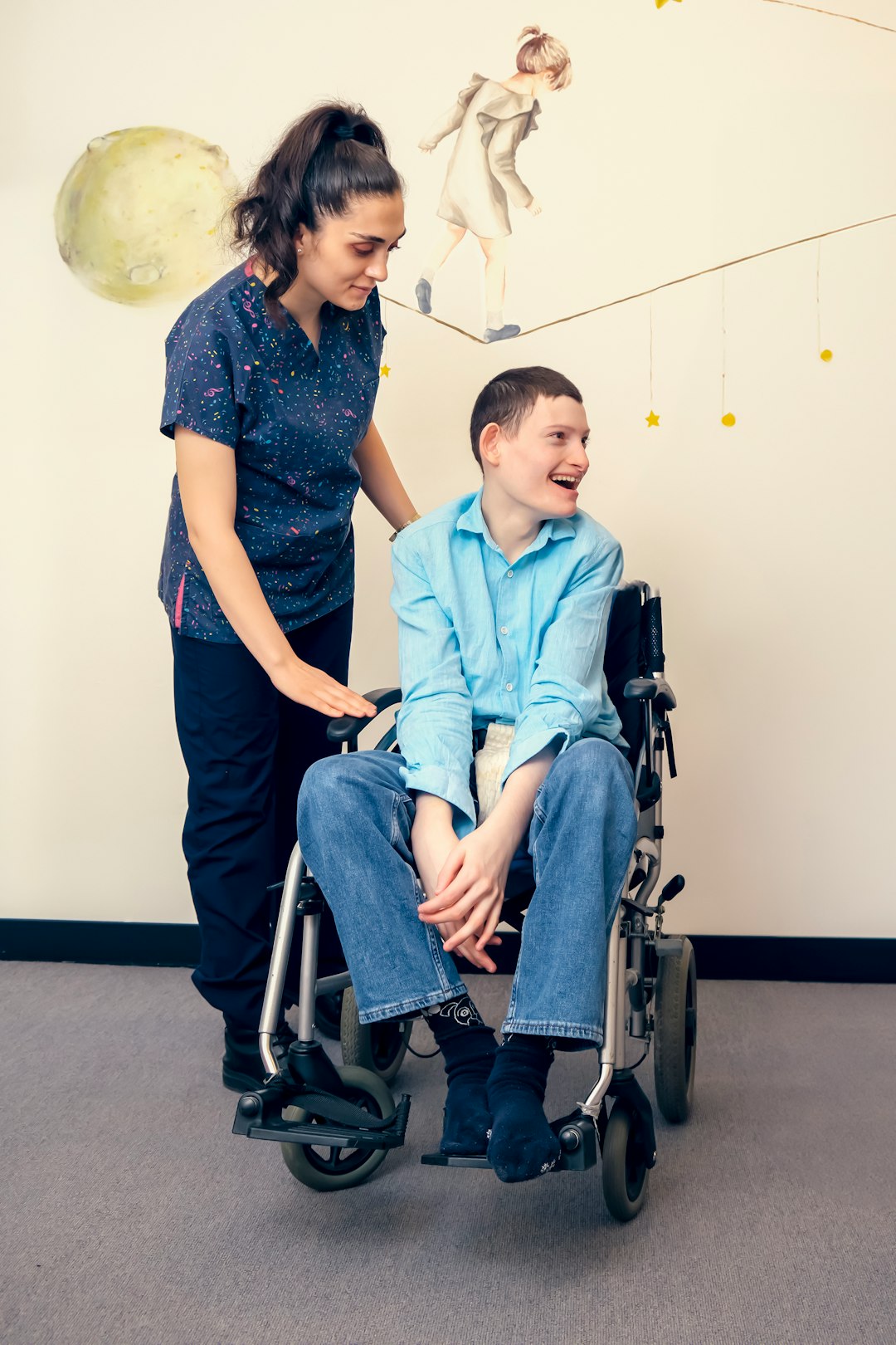 A child with Angelman syndrome and a physiotherapist next to him